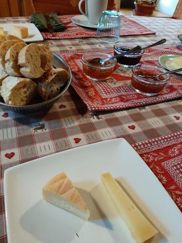 - une table avec une assiette de pain et un bol de beurre dans l'établissement La Boissellerie, à Saulxures-sur-Moselotte