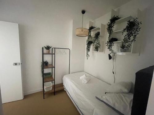 une chambre avec un lit et des plantes sur le mur dans l'établissement Le refuge d Amaya -Btz, à Biarritz