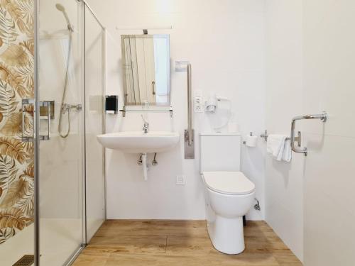 a white bathroom with a toilet and a sink at Bilbao ROOMS Lidon in Bilbao