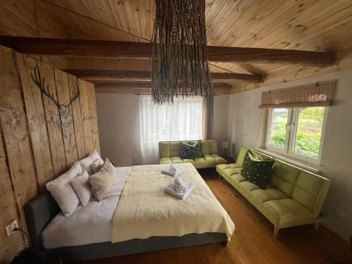 a bedroom with a bed and two green couches at Wąkop 6 Agroturystyka Eco in Nowa Słupia