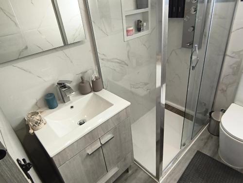 a bathroom with a sink and a shower at Vivenda Terinho in Barcelos