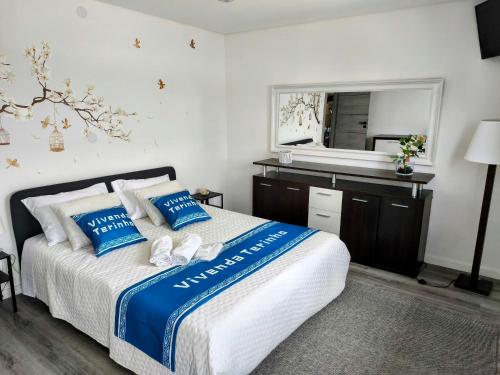 a bedroom with a bed with blue and white pillows at Vivenda Terinho in Barcelos