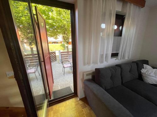 a living room with a couch and a sliding glass door at Terme Čatež apartma Maestro in Čatež ob Savi