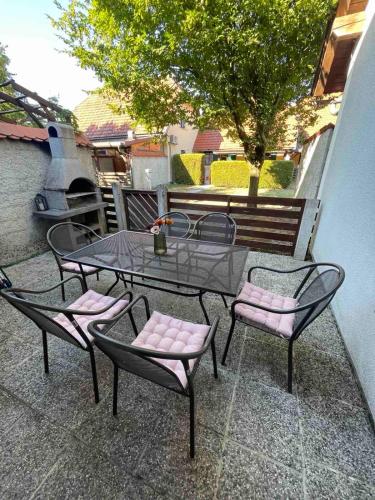 a patio with a table and chairs and a tree at Terme Čatež apartma Maestro in Čatež ob Savi