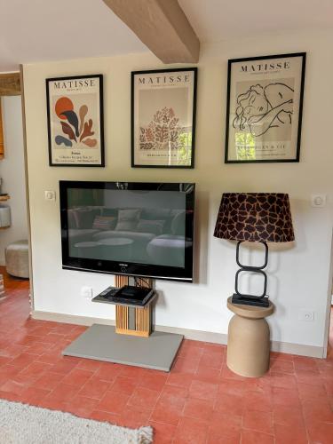 a living room with a flat screen tv on a wall at Au Clos de la Bergerie - campagne, détente & pétanque in Pont-lʼÉvêque