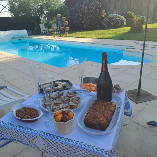 - une table avec de la nourriture et une bouteille de vin dans l'établissement La Garenne, à Virazeil