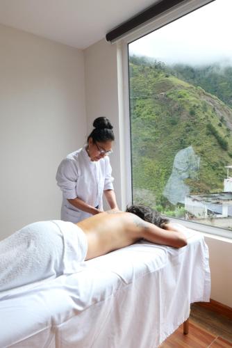 a woman laying on a bed getting a massage at Hotel Shannon 360 in Baños