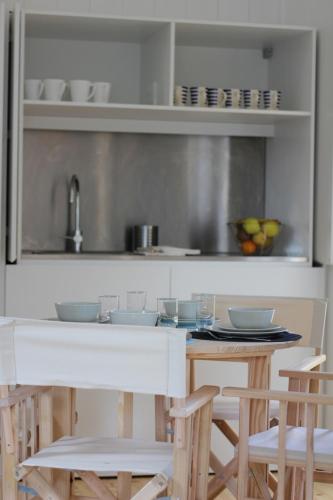 a kitchen with a counter with chairs and a table at Moinhos da Corga in Antigo