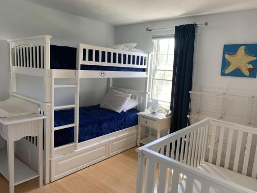 a bedroom with two bunk beds and a window at Katama Family Fun in Edgartown