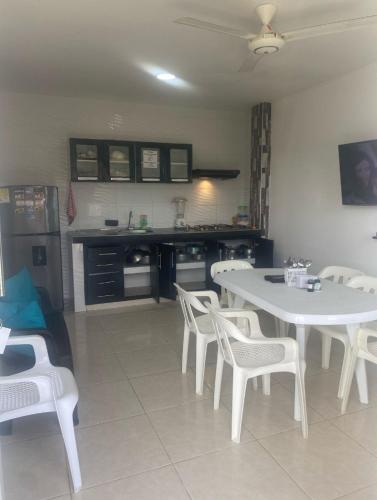 a kitchen with a white table and white chairs at Apartamentos LUISA in Coveñas