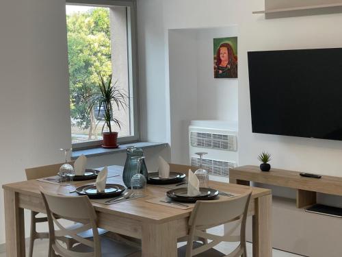 a dining room with a table with chairs and a television at Appartamenti Trillionaire in Rivoli