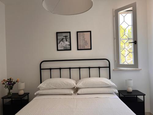 1 dormitorio con 1 cama con 2 mesitas de noche y una ventana en Stella di Mare, en Torre Canne