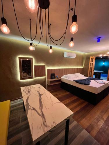 a room with a bed and a table and lights at Mais Hotel in Água Boa