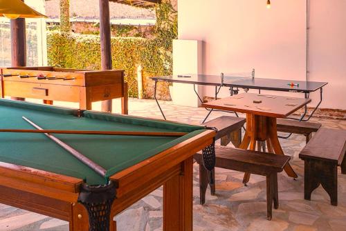 two ping pong tables and benches in a room at Pousada das Videiras boutique in Monte Verde