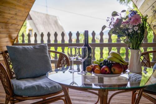 un tavolo di vetro con un cesto di frutta e bicchieri da vino di Chillinn Bikavér Cottage Eger a Eger