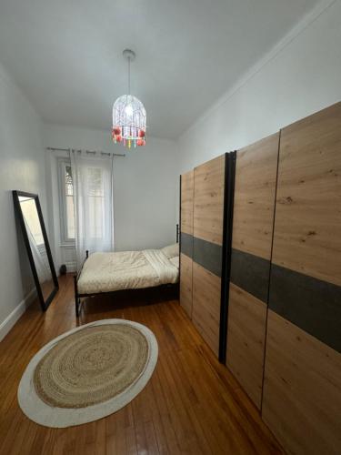 - une chambre avec un lit et une grande armoire en bois dans l'établissement Grand appartement hyper-centre, à Clermont-Ferrand