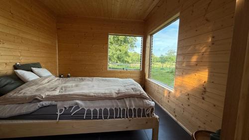 a bed in a wooden room with a window at Küstenglück in Varel
