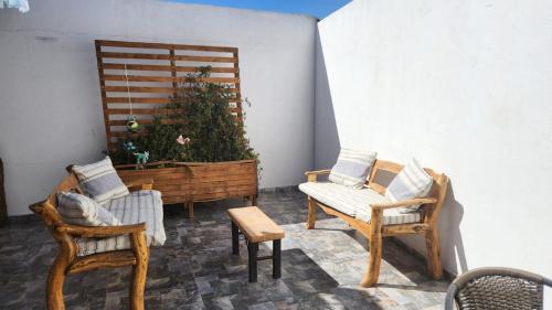a porch with chairs and a planter with a plant at Hostal Malú in San Pedro de Atacama