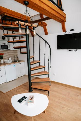 a spiral staircase in a living room with a table at Bungalows Panorama Hills in Pluzine