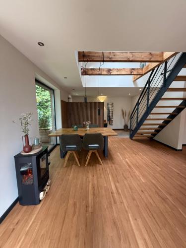 a living room with a table and a staircase at Küstenglück in Varel