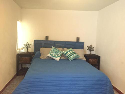 a bedroom with a blue bed with pillows on it at Suites colibri in San Miguel de Allende