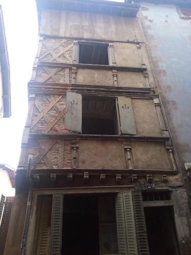 a tall building with windows on the side of it at Guest House in Riom