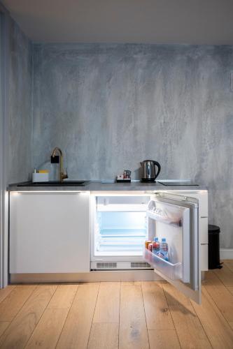 an empty refrigerator with its door open in a kitchen at Apartments AMALFI Old Town FREE Parking in Sarajevo
