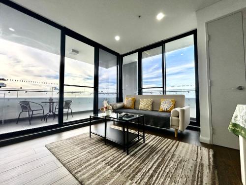 a living room with a couch and a table at Sun-filled Apt w Stunning Open Views of Park&City in Sydney