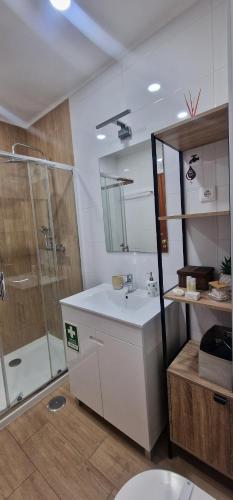 タヴィラにあるTavira Nature Houseの白い洗面台とシャワー付きのバスルーム