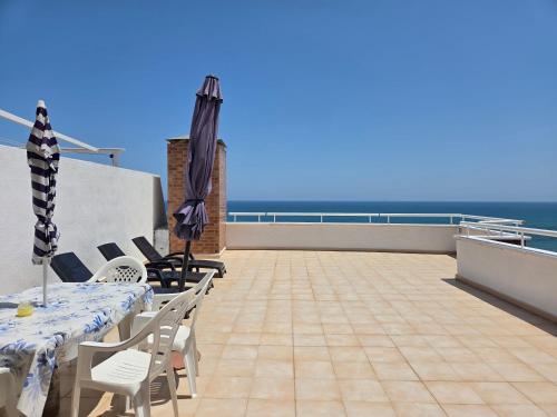 a balcony with a table and chairs and an umbrella at acapulco 3 frontal in Oropesa del Mar