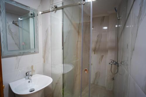 une salle de bain avec une douche en verre et un lavabo dans l'établissement Deluxe Studio in Tangier, à Tanger