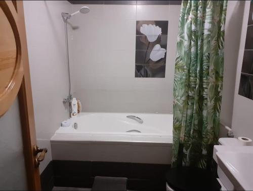 a bathroom with a bath tub and a shower curtain at Beach apartment Agadir in Agadir