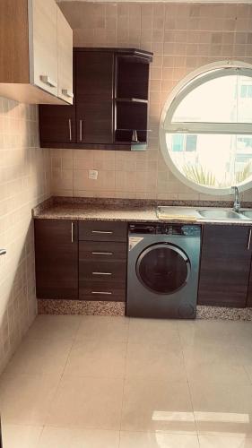 une cuisine avec un lave-vaisselle, un évier et un miroir dans l'établissement Sunset Appartement, à Minaret de Mansuria