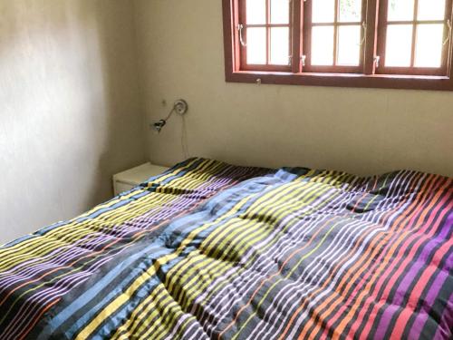 a bed with a colorful comforter in a bedroom at 6 person holiday home in Løgstør in Løgstør