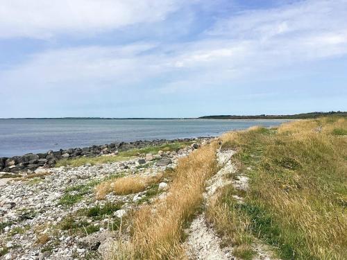 a field of grass next to a body of water at 6 person holiday home in Løgstør in Løgstør