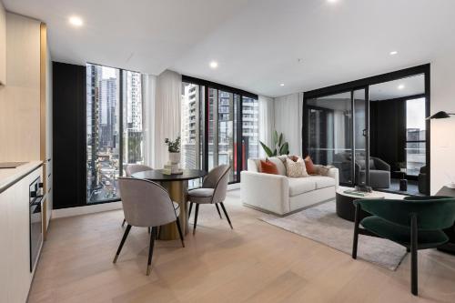 a living room with a couch and a table and chairs at Urban Rest City Road in Melbourne