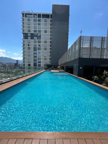 a large swimming pool on the roof of a building at Elegante loft apartment Paseo Santa Lucia king size bed, alberca, gym, parking, kids club in Monterrey