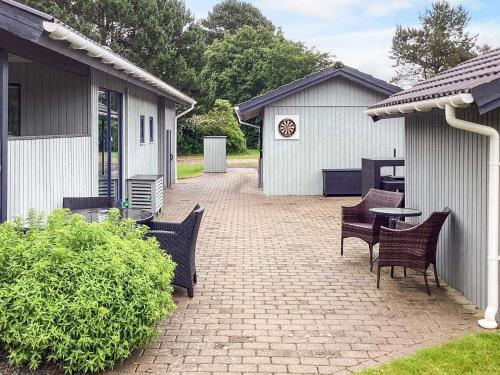 a patio with chairs and a table and a building at 8 person holiday home in Nakskov in Nakskov