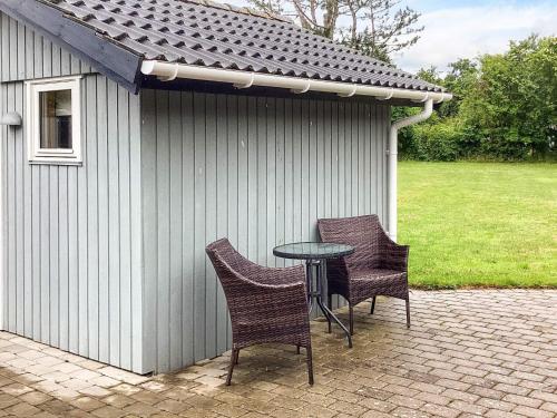 a patio with two chairs and a table in front of a building at 8 person holiday home in Nakskov in Nakskov