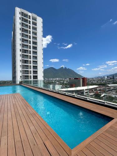 a swimming pool on the roof of a building at Elegante loft apartment Paseo Santa Lucia king size bed, alberca, gym, parking, kids club in Monterrey