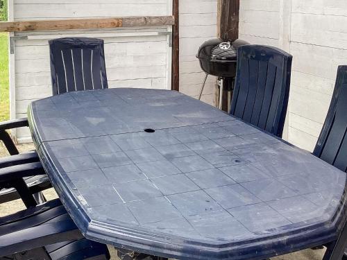 a blue table with two chairs and a grill at 6 person holiday home in Horslunde in Horslunde