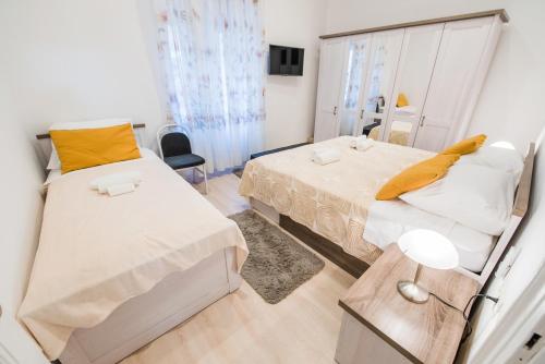 a bedroom with two beds and a table with a lamp at Apartment Vetom in Split
