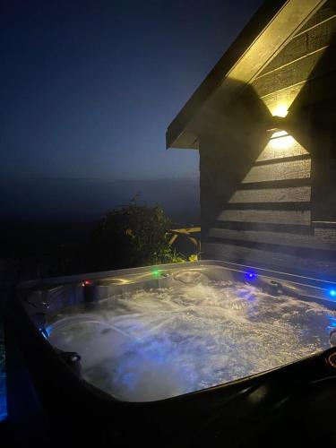 a hot tub on the side of a house at night at Large fully renovated farmhouse with indoor Swim spa and Sauna in Lemmer