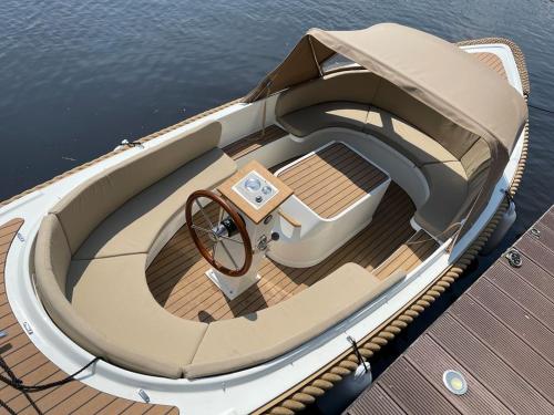 a boat sitting on top of the water at Large fully renovated farmhouse with indoor Swim spa and Sauna in Lemmer