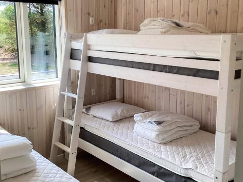 two bunk beds in a room with a window at 5 star holiday home in Højslev in Højslev