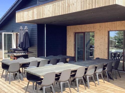 a large table and chairs on a wooden deck at 5 star holiday home in Højslev in Højslev