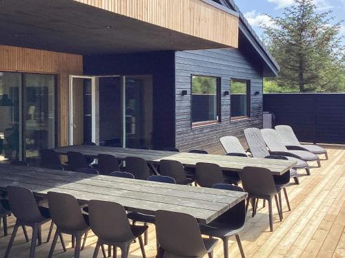 a large wooden table and chairs in front of a building at 5 star holiday home in Højslev in Højslev
