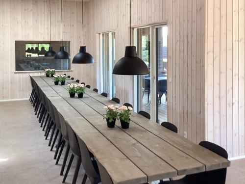 a long table in a room with chairs and pendant lights at 5 star holiday home in Højslev in Højslev