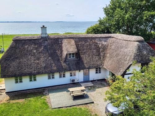 an old house with a thatched roof and a picnic table at 8 person holiday home in Svendborg in Svendborg
