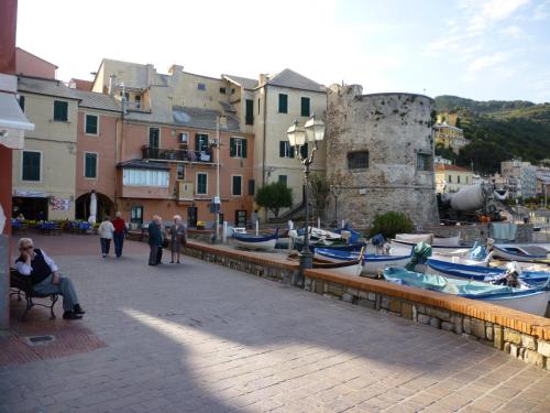 a group of people walking around a harbor with boats at Chà Apartment in Laigueglia